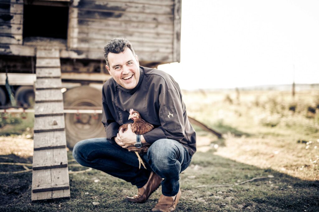 Werbefotografie - Gasthaus Jungwirt - Portrait von Johann Jungwirt mit einem Huhn in der Hand