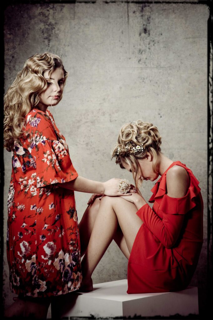 Portraitfotografie- zwei Geschwister (Mädchen) - Shooting im Fotostudio - grauer Hintergrund- rote Kleidung