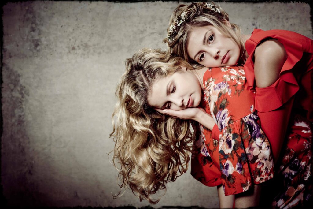 Portraitfotografie- zwei Geschwister (Mädchen) - Shooting im Fotostudio - grauer Hintergrund- rote Kleidung