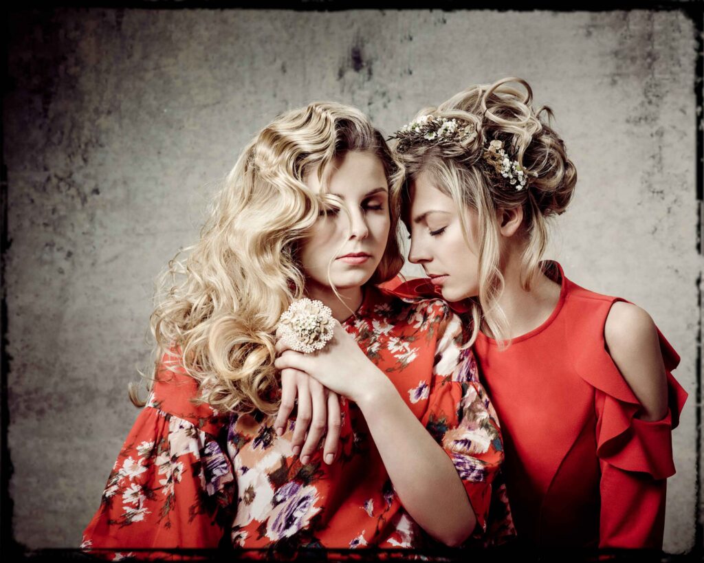 Portraitfotografie- zwei Geschwister (Mädchen) - Shooting im Fotostudio - grauer Hintergrund- rote Kleidung