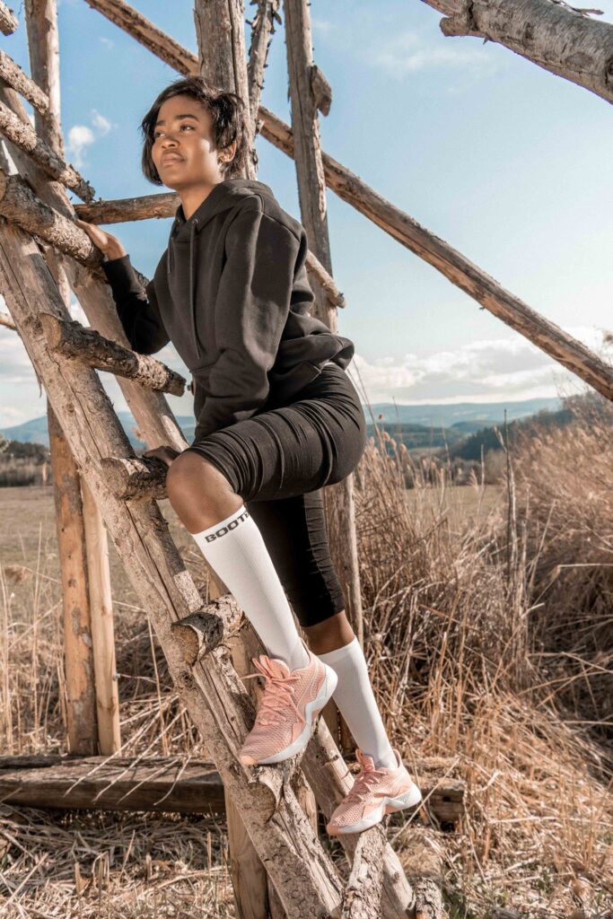 Werbefotografie - Bootdoc - Wintersteiger - Sportsocken - onlocation - Model klettert einen Hochsitz rauf