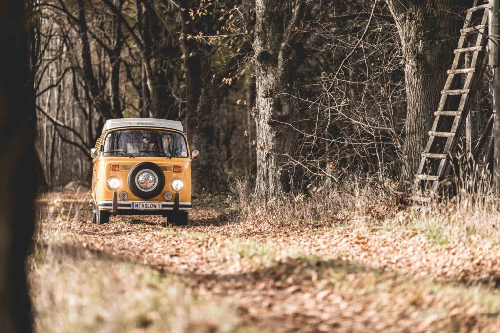 Werbefotografie - Jörgbauer - VW Bus fährt in einen Wald - Campingsituation
