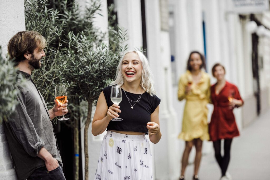 Werbefotografie für das Getränk "Pino's" - Mehrere Leute im Gastgarten einer Bar