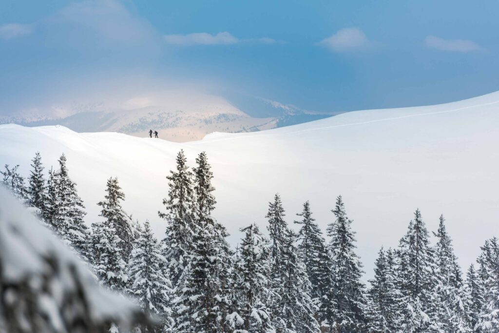 Werbefotografie für die Lipizzanerheimat im Winter - Schneelandschaft mit zwei Wanderer in der Entfernung