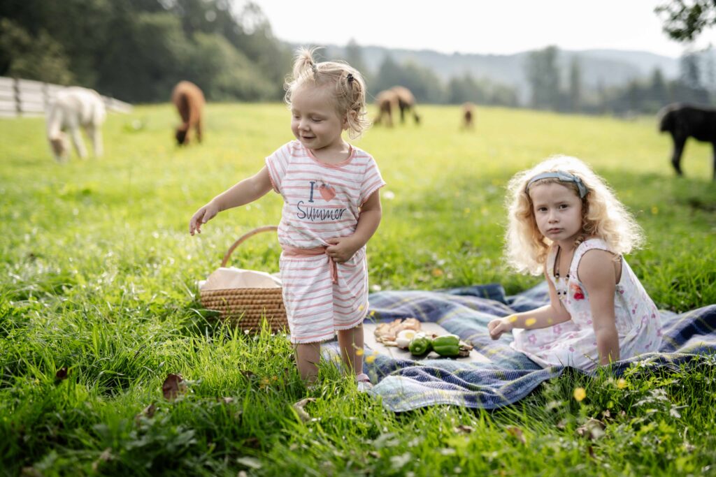 Werbefotografie LaPaca - Portraitfotografie von Kindern in einem Garten mit Alpakas
