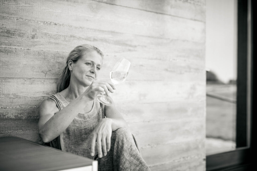 Werbefotografie- Aufnahme einer Winzerin an einer Wand lehnend