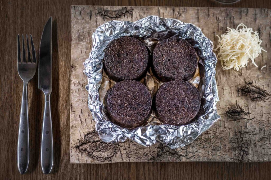 Foodfotografie einer Blutwurst- sie ist in vier scheiben geschnitten und liegt in einer Alufolie