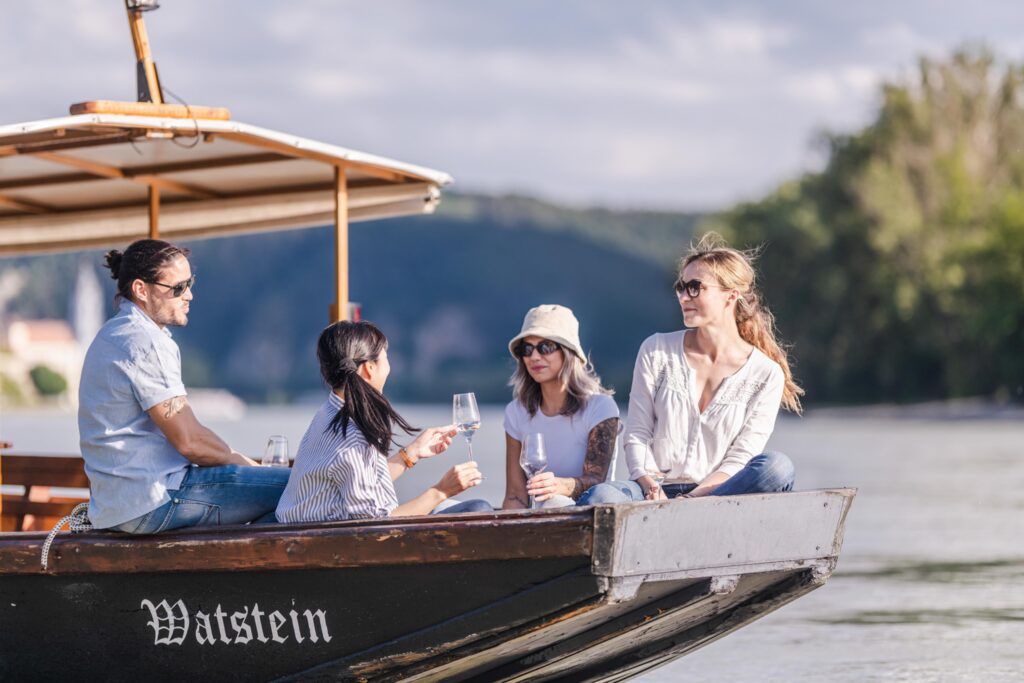Ein Mann, drei Frauen sind auf einem Boot und haben spaß miteinander