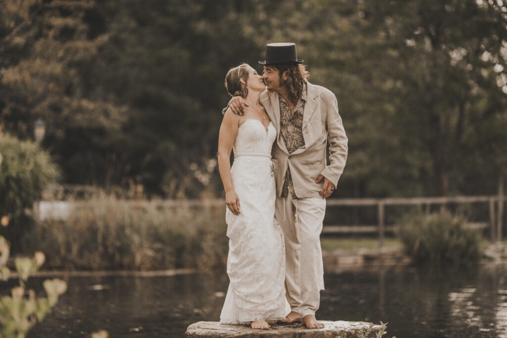 Hochzeitsfotografie- Brautpaar steht auf einem Stein in einem See