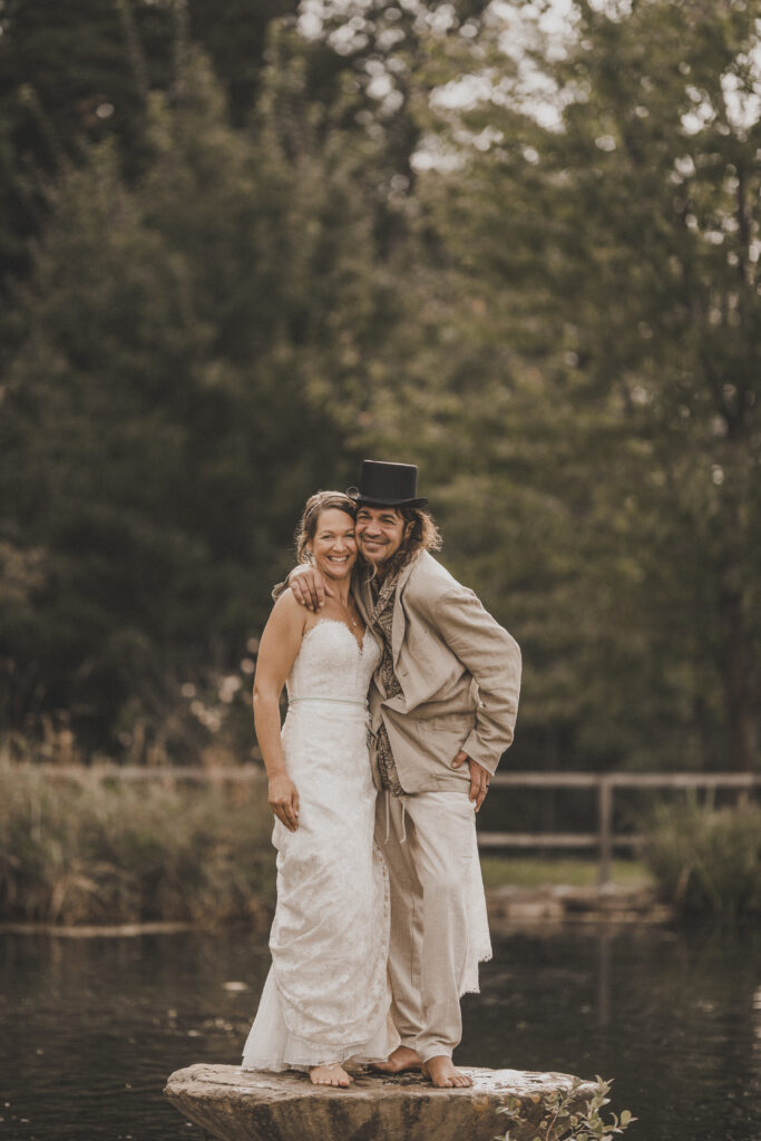 Hochzeitsfotografie- Brautpaar steht auf einem Stein in einem See