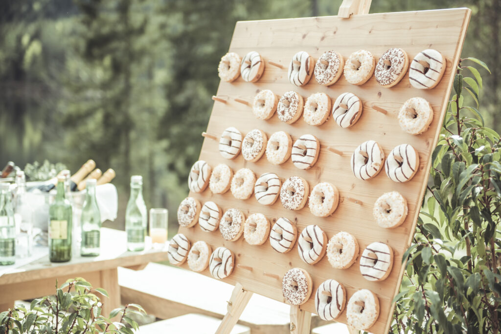 Hochzeitsfotografie- Detailaufnahme einer Holzwand, an der Donuts hängen