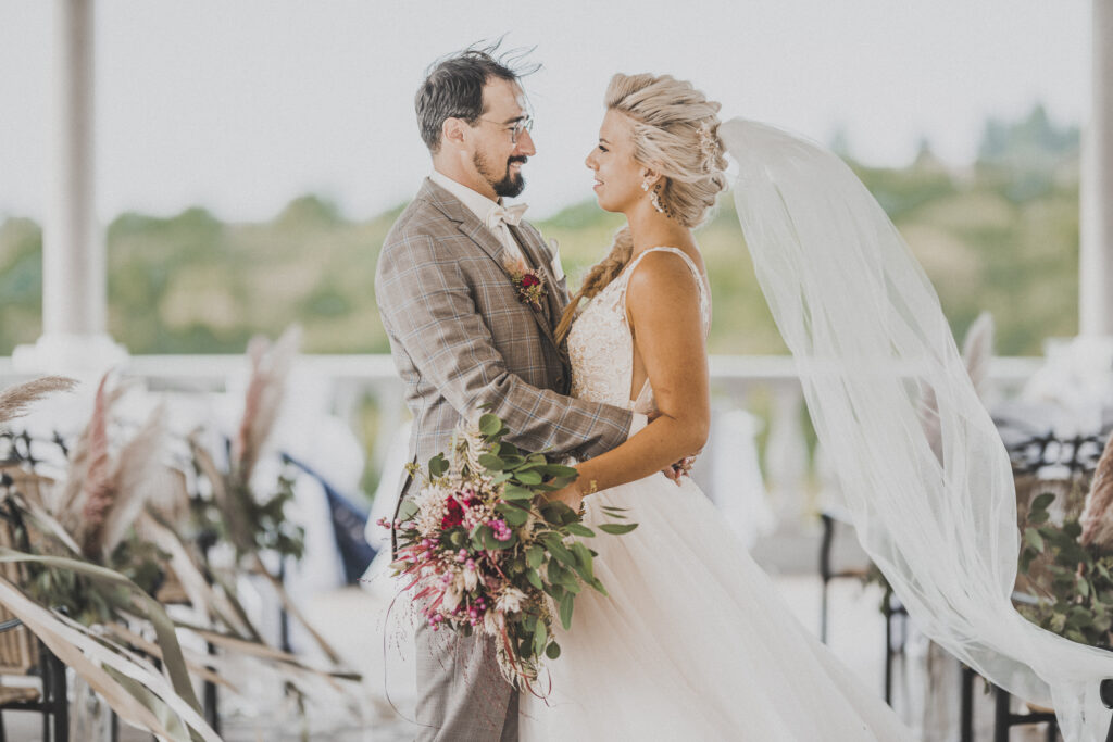 Hochzeitsfotografie- junges Brautpaar steht in der leeren Location und sieht sich an