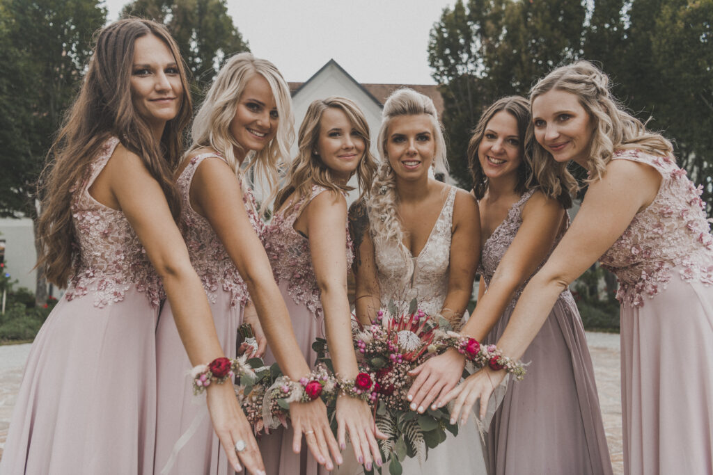 Hochzeitsfotografie- eine Gruppe junger Frauen stehen im Halbkreis und zeigen ihren Handschmuck