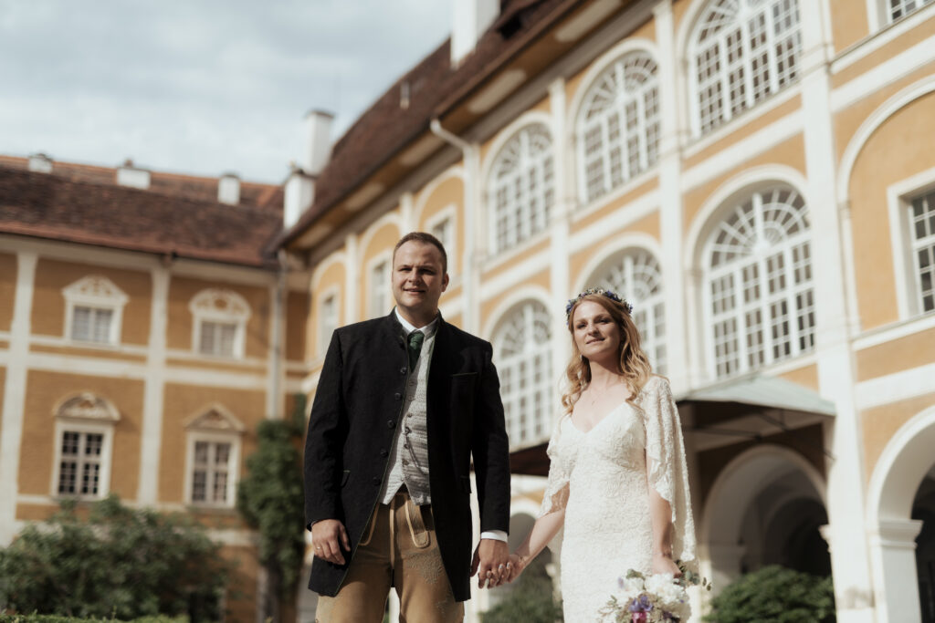 Hochzeitsfotografie- Aufnahme eines Brautpaares vor einem Schloss