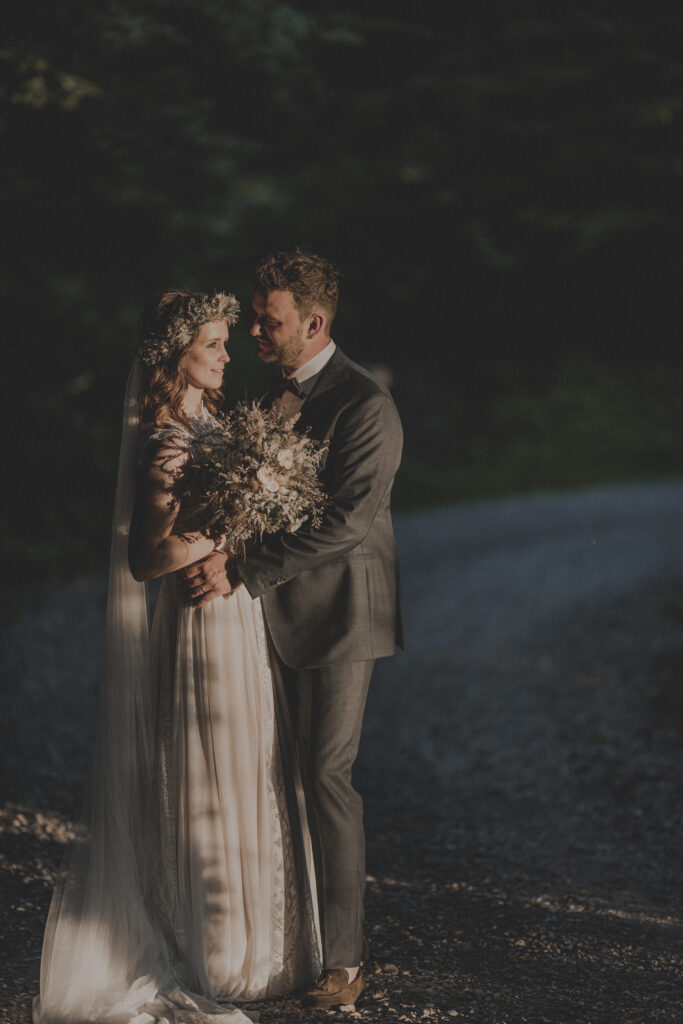 Hochzeitsfotografie- Porträtaufnahme eines Brautpaares in einem Wald, sehr dunkel