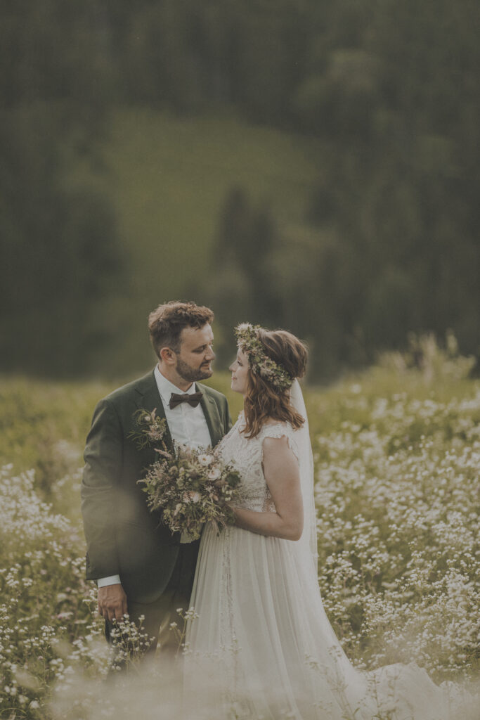 Hochzeitsfotografie-Porträtaufnahme eines Brautpaares in einer Weiße stehend und lachend