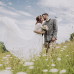Hochzeitsfotografie- ein junges Brautpaar in der Wiese stehend