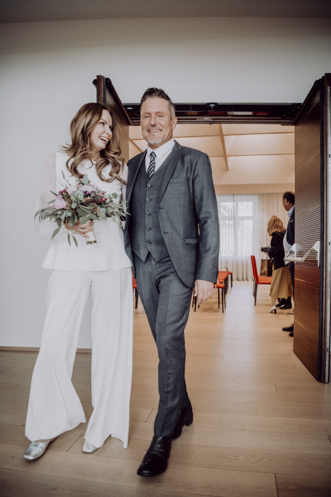 Hochzeitsfotografie- Porträtaufnahme eines Brautpaares beim Einzug in das Standesamt
