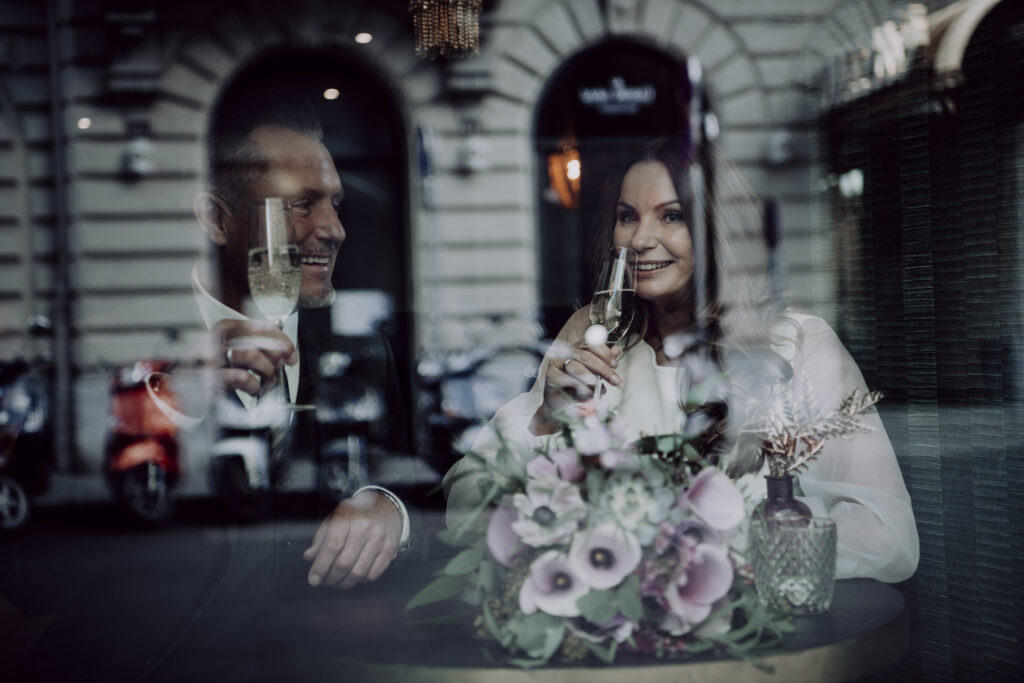 Hochzeitsfotografie- Porträt eines Brautpaares durch eine Glasscheibe fotografiert