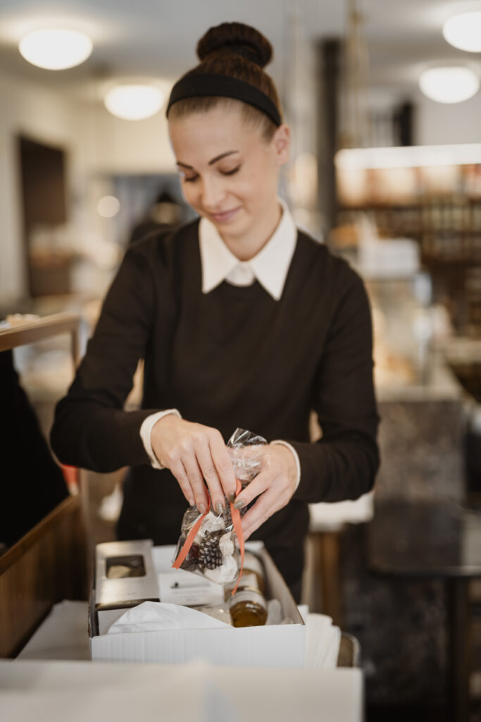 Werbefotografie- Porträt einer jungen Dame im Lokal "Frankowitsch" beim Geschenke einpacken