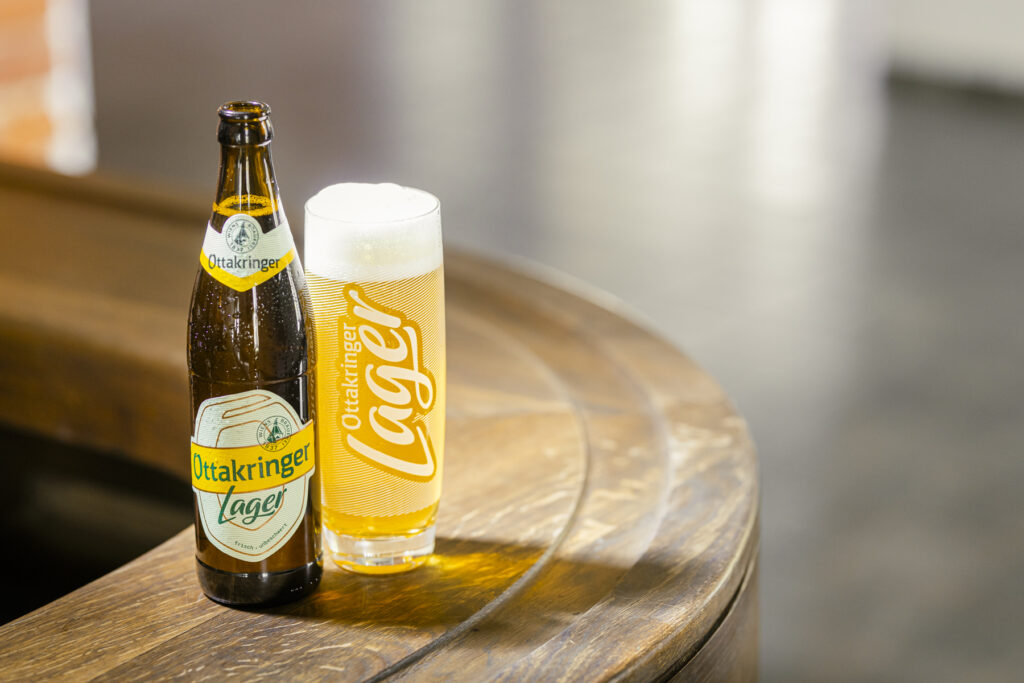 Werbefotografie/Produktfotografie einer Bierflasche und eines Bierglases auf einer Bar stehend