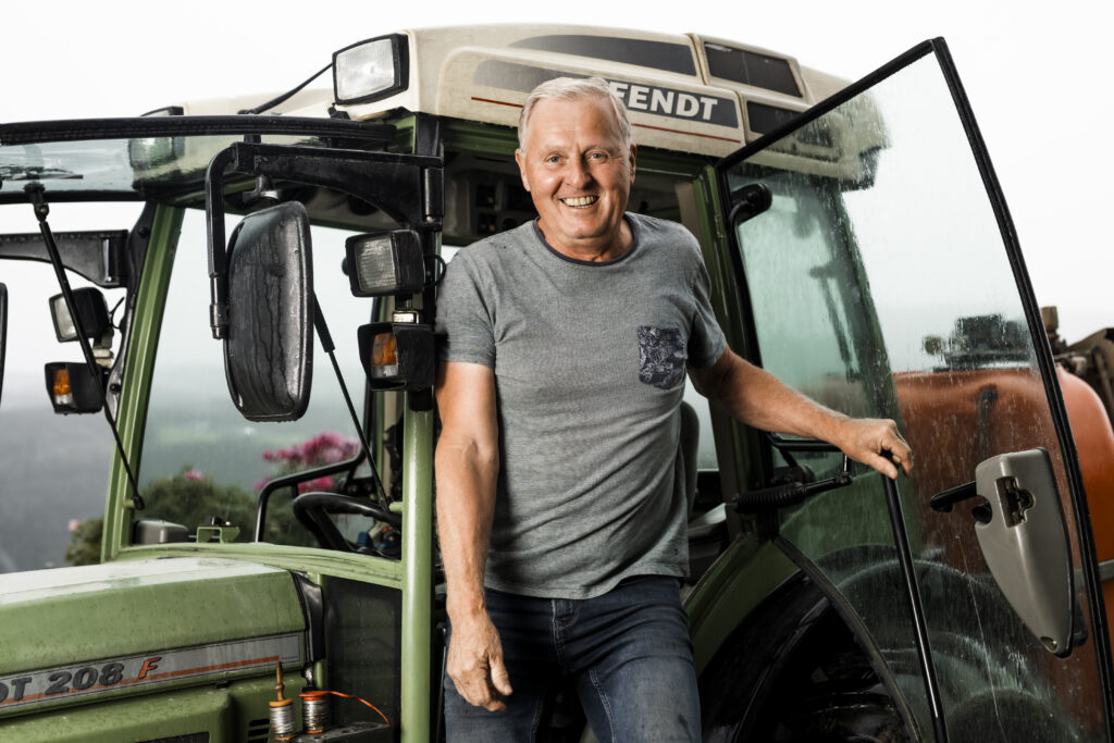 Werbefotografie- älterer Mann steigt aus einem Traktor aus