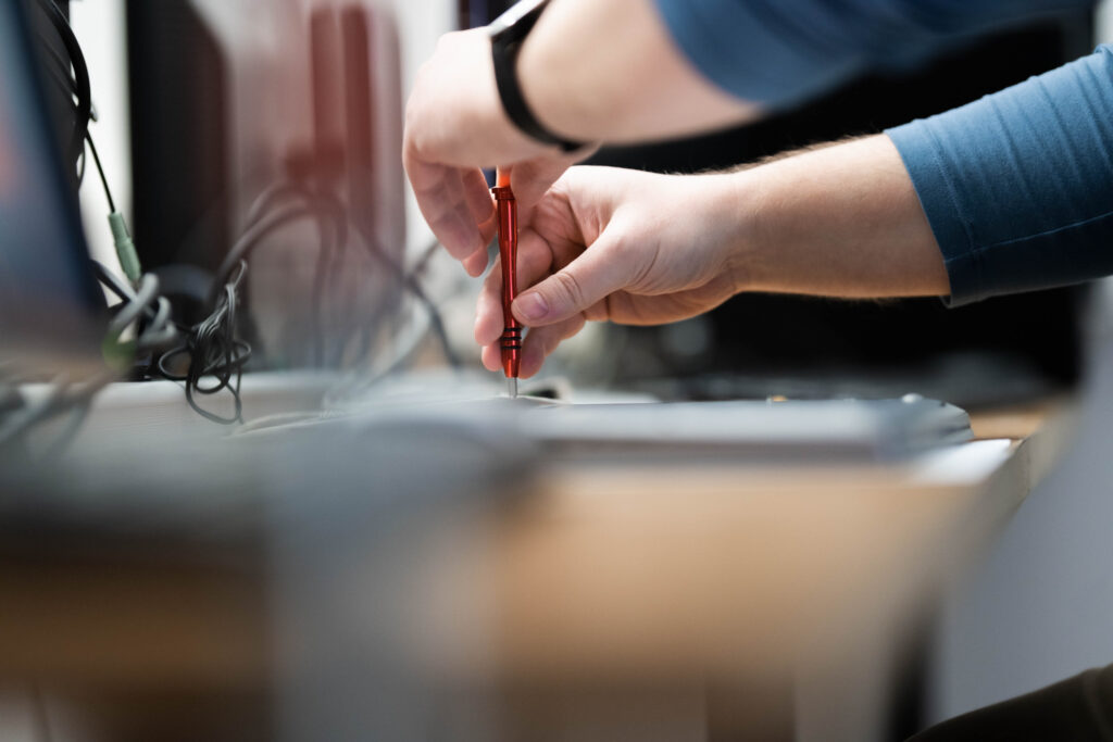 Werbefotografie Comm-Unity EDV- Detailaufnahme einer Hand bei der Reparatur eines Computers