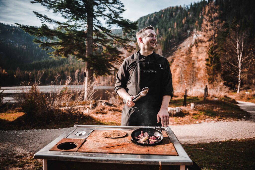 Werbefotografie für Genuss am See - Portraitaufnahme des Kochs (outdoor) an einem Tischherd