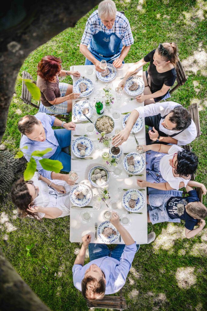 Werbefotografie - Michaelerhof - Mehrere Leute an einem Tisch im Garten beim Essen und Trinken- von Oben fotografiert