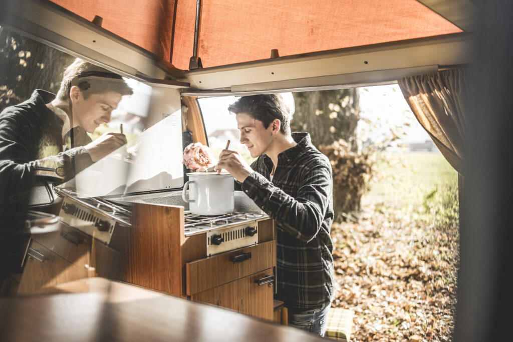 Werbefotografie - Jörgbauer - VW Bus fährt in einen Wald - Campingsituation