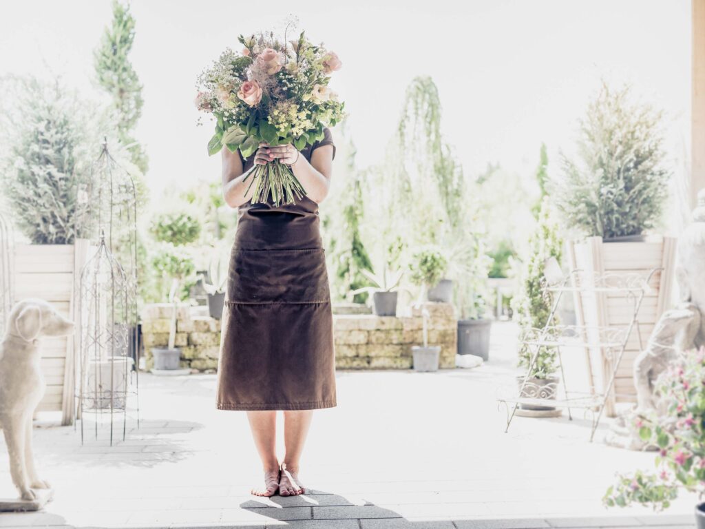 Werbeaufnahme für das Geschäft/Cafe Livios - Aufnahme eines Menschen mit einem großen Blumenstrauß vorm Gesicht