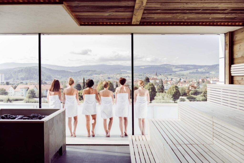 Werbefotografie Sauna Therme Nova - eine Gruppe von Menschen stehen am Balkon und sehen sich das Panorama an
