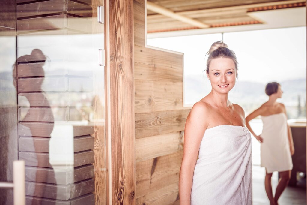 Werbefotografie Sauna Therme Nova - junge Dame steht am Eingang einer großen Sauna