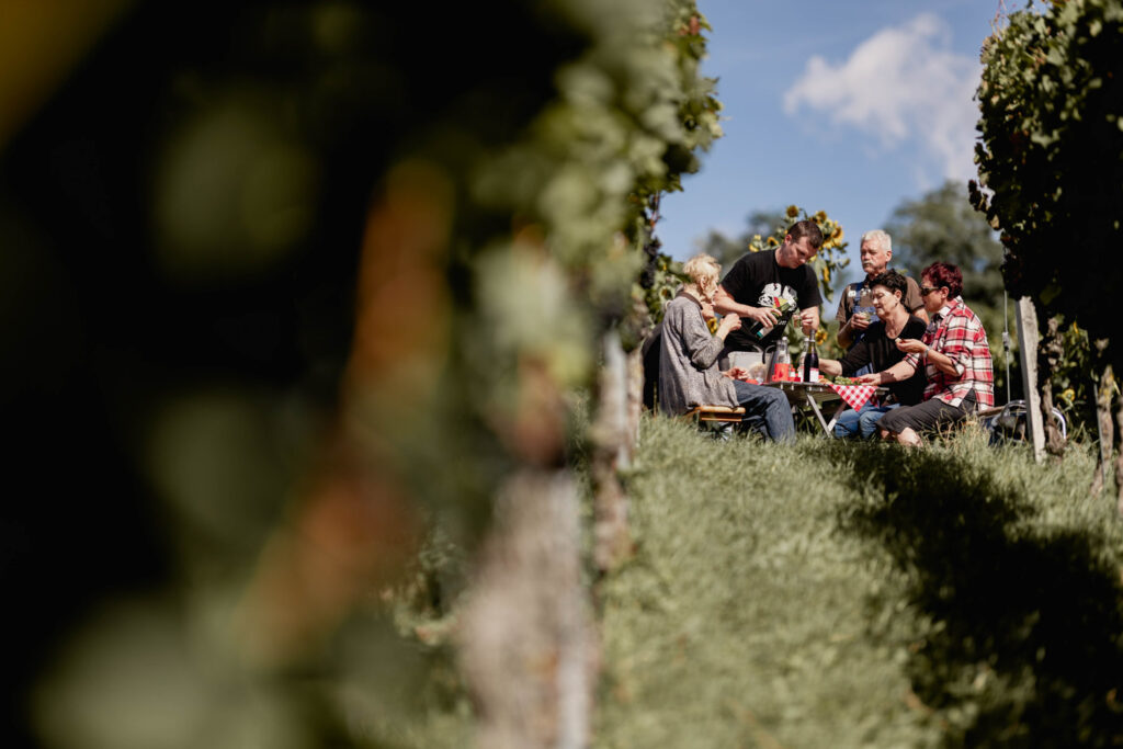 Werbefotografie Winzergenossenschaft Achkarren - Imagefoto mehrerer Leute, die eine Pause von der Arbeit im Weingarten machen
