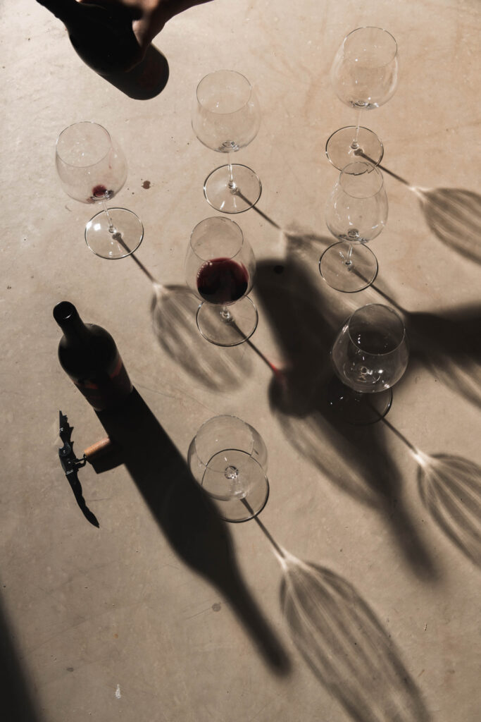 Produktfoto von mehreren Weingläsern die am Boden stehen und einen langen Schatten werfen