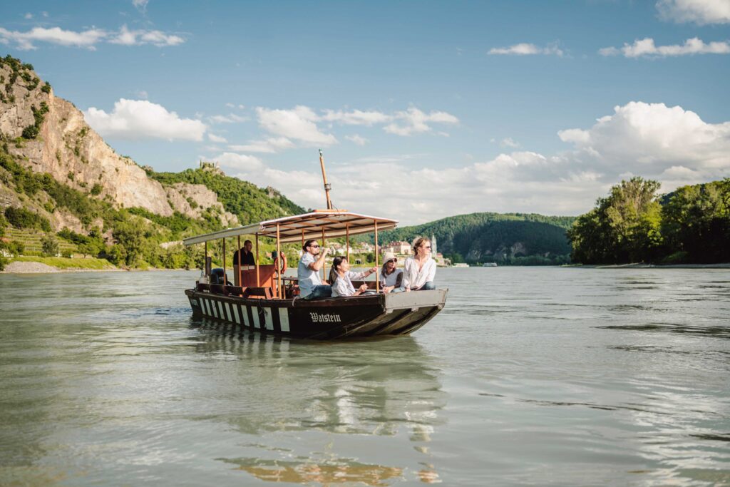 Man sieht ein Boot auf der Donau in der Wache fahren