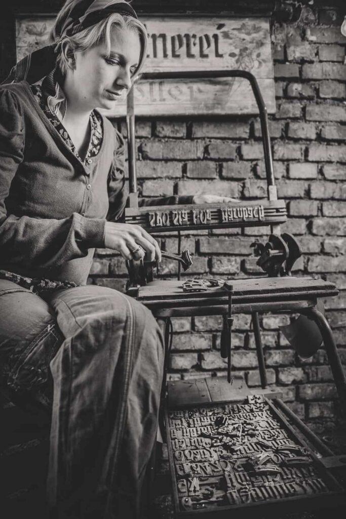 Eine Frau sitzt in Vintagekleidung gekleidet an einem Tischchen