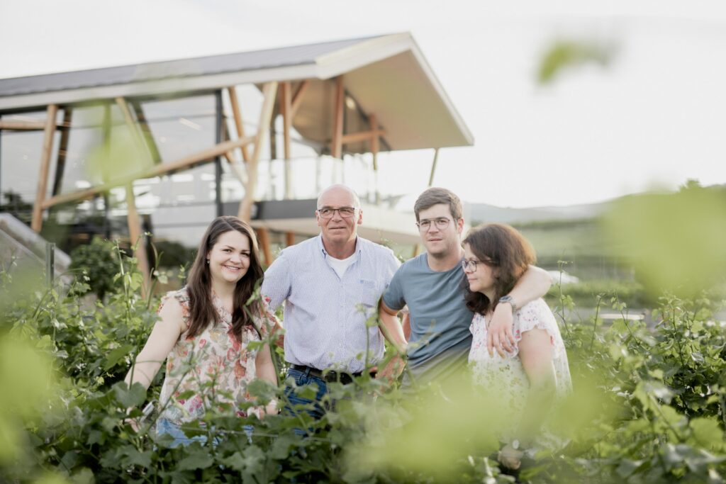 Werbefotografie Weingut Reinhardt/ Architekturaufnahme des Weinguts - davor die Familie Reinhardt