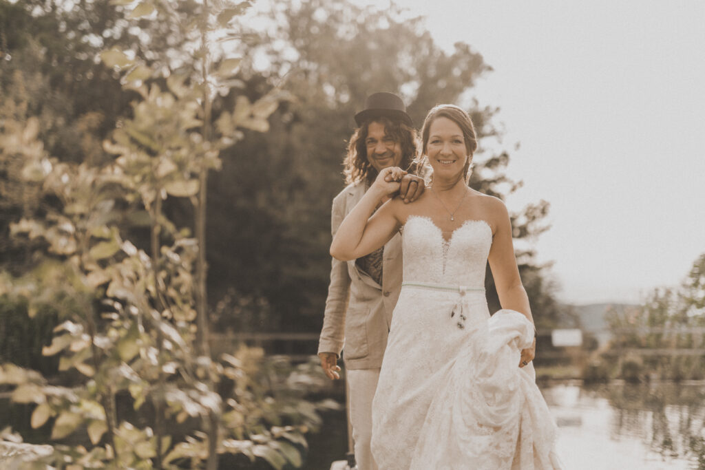 Hochzeitsfotografie- Brautpaar steht in der Natur und lächelt sich an