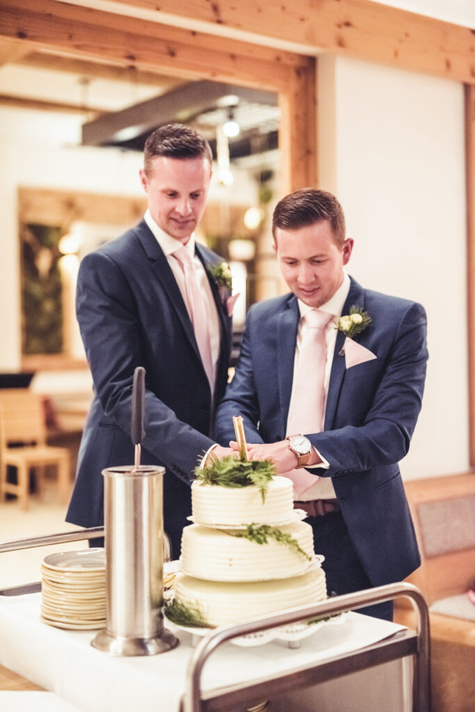 Hochzeitsfotografie - Porträtaufnahme eines homosexuellen Brautpaares beim Torte anschneiden