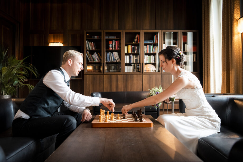 Hochzeitsfotografie- Porträtaufnahme eines Brautpaares beim Schachspielen