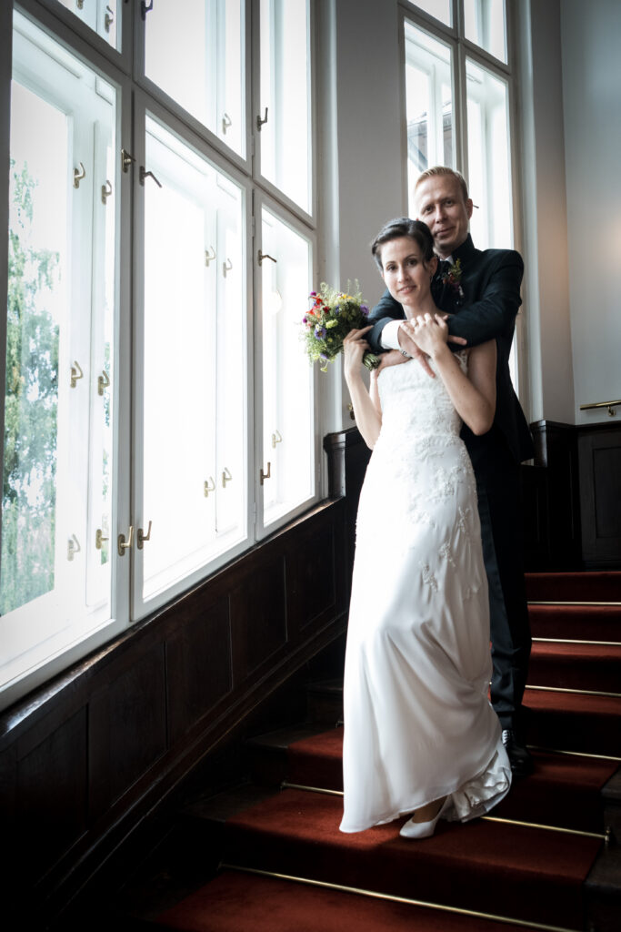 Hochzeitsfotografie - Porträtaufnahme eines Brautpaares auf einer Stiege stehend