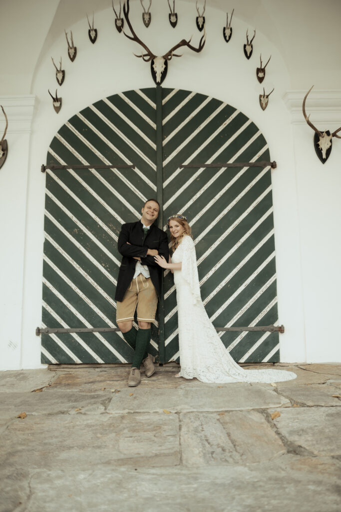 Hochzeitsfotografie- Porträtaufnahme eines Brautpaares vor einer grünen Holztür
