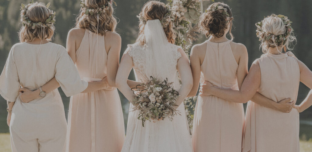 Hochzeitsfotografie- Porträtaufnahme der Brautjungfern im rosaroten Kleid, die Braut steht in der Mitte