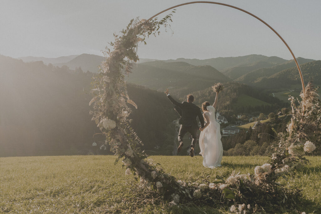 Hochzeitsfotografie- Porträtaufnahme eines Brautpaares beim Springen