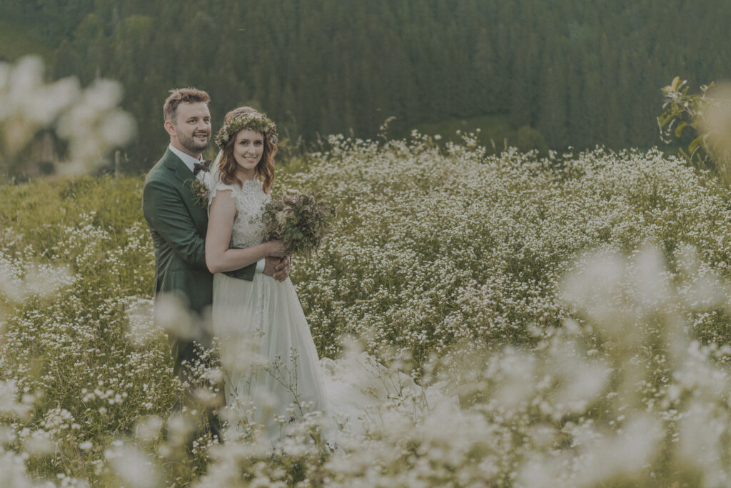 Hochzeitsfotografie-Porträtaufnahme eines Brautpaares in einer Weiße stehend und lachend