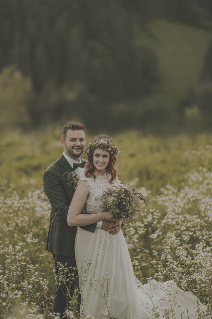 Hochzeitsfotografie-Porträtaufnahme eines Brautpaares in einer Weiße stehend und lachend