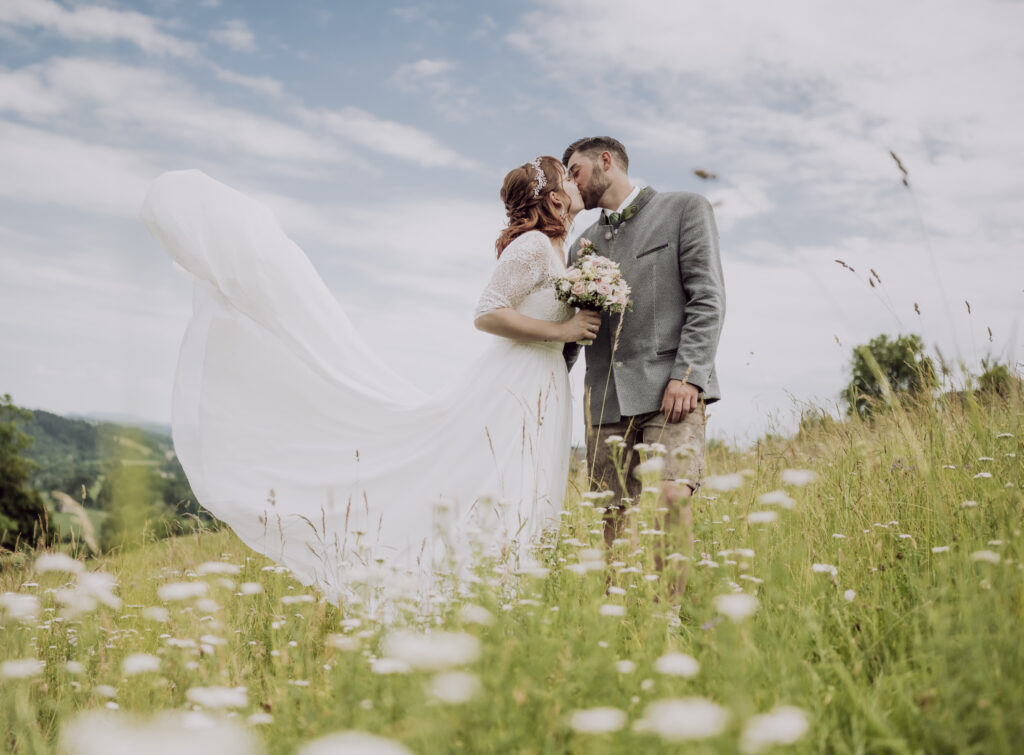 Hochzeitsfotografie- ein junges Brautpaar in der Wiese stehend
