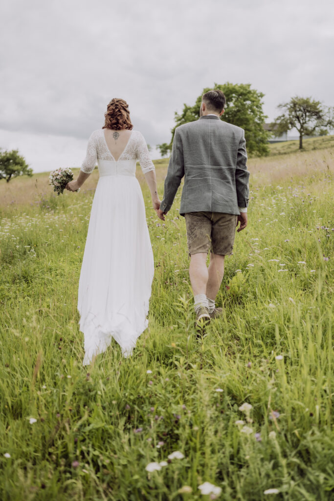 Hochzeitsfotografie- ein junges Brautpaar in der Wiese stehend