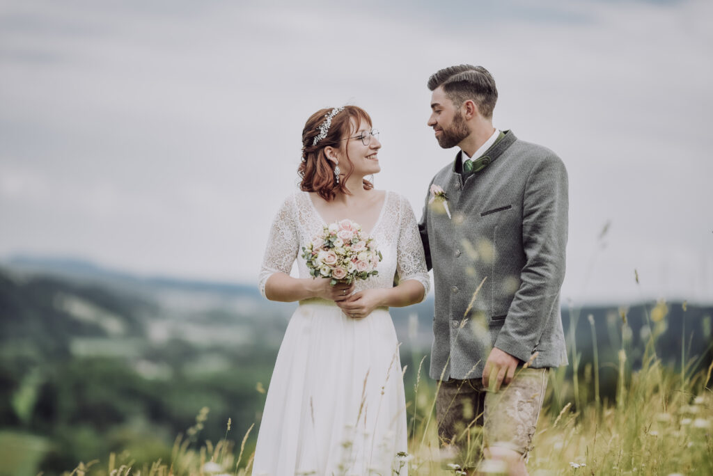 Hochzeitsfotografie- ein junges Brautpaar in der Wiese stehend